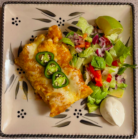 Homemade chicken enchiladas with red enchilada sauce, melted cheese and fresh jalapeños